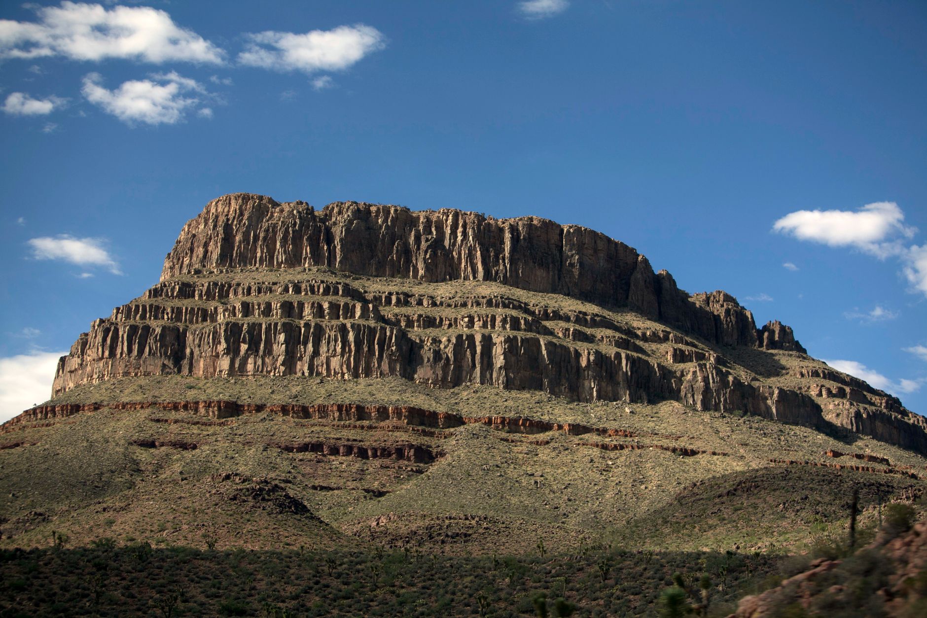 A stunning view of a rocky plateau under a clear blue sky in Arizona's vast desert landscape.