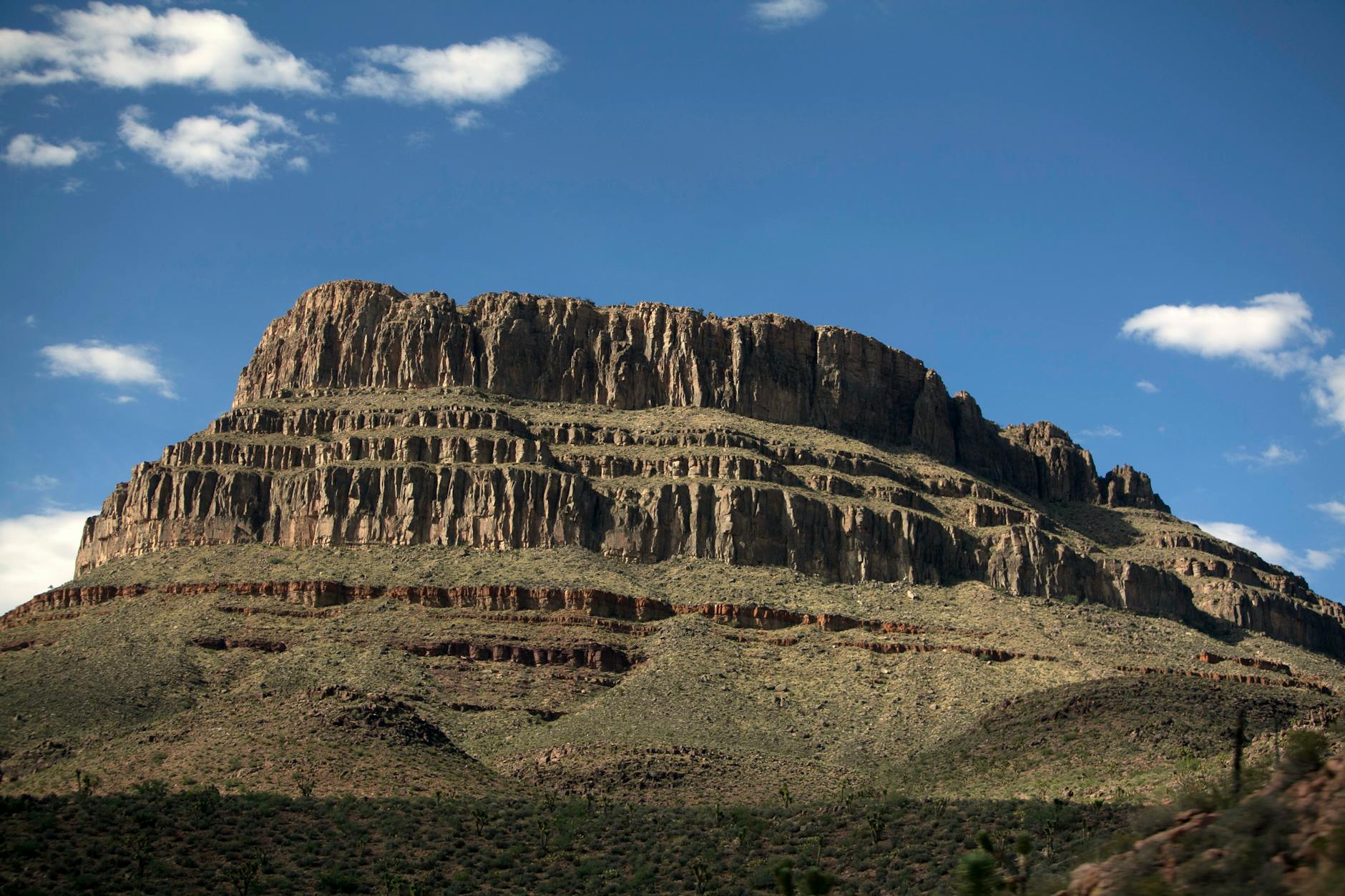 A stunning view of a rocky plateau under a clear blue sky in Arizona's vast desert landscape.